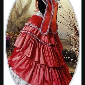 May include: A red, ruffled, layered cape with a white lace trim. The cape is worn over a white dress with a floral pattern. The person is wearing a white straw hat with a red ribbon.