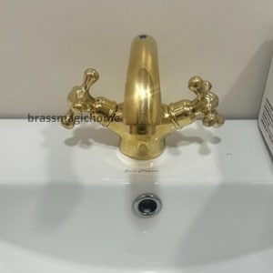 Torneira de lavatório de latão sem verniz com furo único e duas alças simples em cruz.