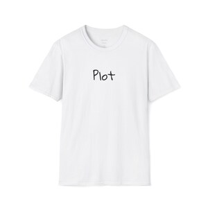 Puede incluir: Camiseta blanca de cuello redondo con la palabra "Plot" impresa en negro en el centro. La camiseta tiene mangas cortas y un diseño minimalista, adecuada para uso casual.