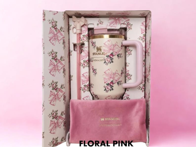 Puede incluir: Un termo Stanley rosa floral con pajita y asa a juego, presentado en una caja decorativa. El termo tiene un fondo crema con estampados florales rosas. Se incluye una bolsa de terciopelo rosa. La caja y el termo est&aacute;n etiquetados "Floral Pink".