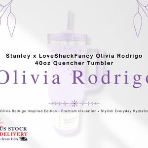 Op de afbeelding: Een lichtpaarse 1,18L Quencher Tumbler met een handvat en een rietje. De tumbler heeft een sterrenpatroon en de naam "Olivia Rodrigo" wordt weergegeven. De tekst "Stanley x LoveShackFancy" is ook zichtbaar.