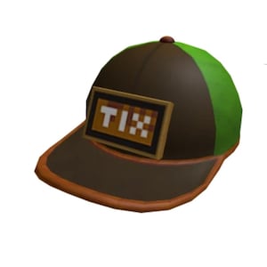 Könnte beinhalten: Eine braune und grüne Baseballkappe mit gebogenem Schirm. Die Kappe hat ein rechteckiges Patch mit dem Wort "TIX" in pixeligen weißen Buchstaben. Der Rand ist orange umrandet.