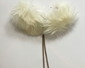May include: White faux fur collar with two brown leather ties. The collar is attached to a white tag with the text "SOMETHING"