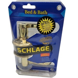 May include: A gold-colored Schlage door handle set in a plastic package. The package has a blue background with the text "Bed & Bath" and "Upgrade Your Home..." The package also includes information about rebates and a full warranty.