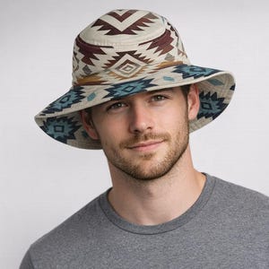May include: A wide-brimmed hat featuring a Southwestern geometric pattern in cream, brown, and teal. The hat has a rounded crown and a wide brim, suitable for sun protection. The hat is made of a soft, durable material.