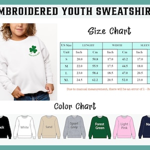 May include: White embroidered youth sweatshirt with a green shamrock and the text "Lucky Little Boss". The size chart shows measurements in inches and centimetres. Available colours include black, white, sand, sport grey, forest green, light pink, and navy.