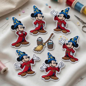 May include: A collection of embroidered patches featuring Mickey Mouse in a sorcerer's outfit. The patches showcase Mickey in a red robe and blue wizard hat with gold stars and a crescent moon. Other patches include a broom and buckets.