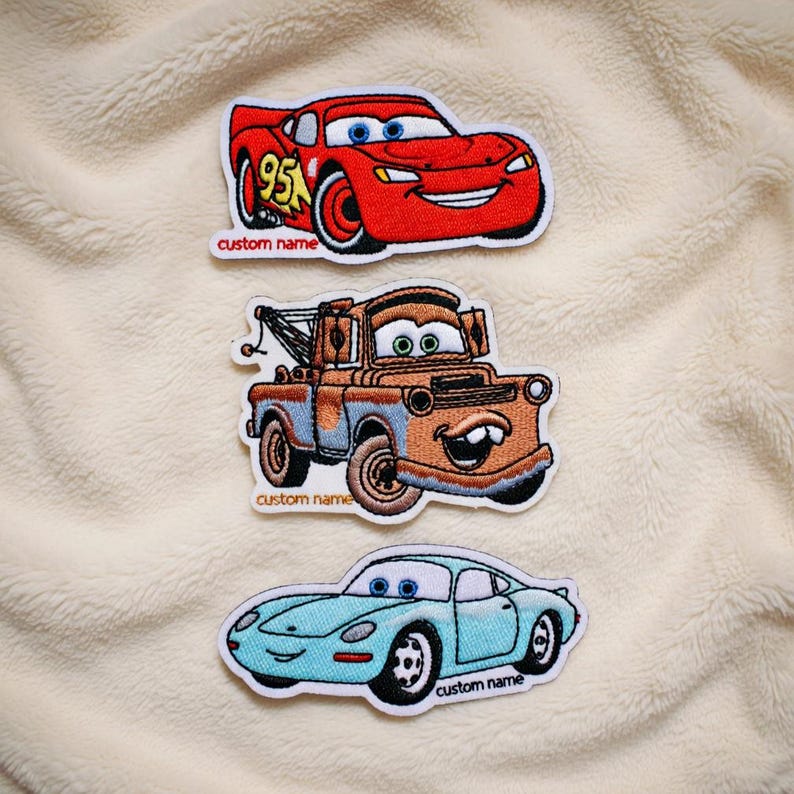 May include: Three embroidered car patches. A red race car with the number 95, a brown tow truck, and a light blue sports car. Each patch has the text "custom name" below the car.