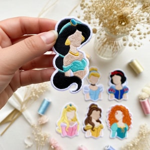 Puede incluir: Parches bordados con diseños de princesas de dibujos animados. Los parches incluyen a Jasmine, Cenicienta, Blancanieves, Aurora, Bella y Mérida. Cada parche tiene un borde blanco y está hecho con hilo colorido.