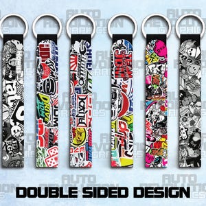 May include: Six keyrings with sticker designs, each featuring a different pattern of colourful graphics and text. The keyrings have a black strap and a silver ring. The text "DOUBLE SIDED DESIGN" is at the bottom.