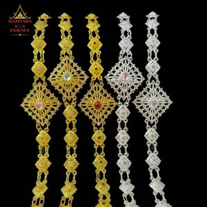 May include: Five ornate metal bracelets arranged vertically, featuring intricate filigree patterns and central oval-shaped cabochon stones. Three bracelets are gold-toned, and two are silver-toned. The text SIAMTADA ESSENCE appears in the top left corner.