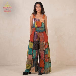 May include: A colorful patchwork jumpsuit with wide legs and large front pockets. The jumpsuit features a variety of patterned fabrics in shades of orange, teal, purple, and green. The straps are a solid orange color. The text "SIAMTADA ESSENCE" is in the upper left corner.