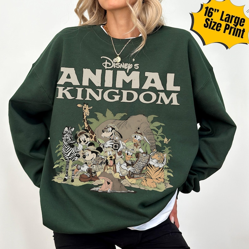 May include: Dark green sweatshirt featuring the text "Disney's Animal Kingdom" above a graphic of Disney characters including Mickey Mouse, Donald Duck, and Goofy. The graphic is a 16-inch large size print.