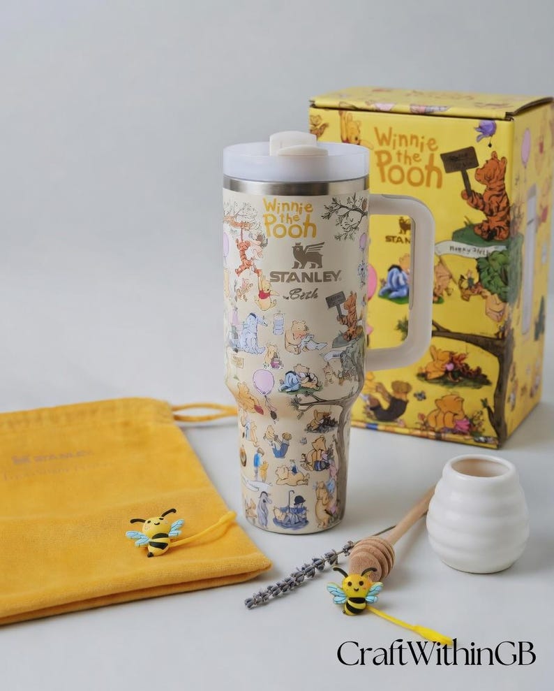 Puede incluir: Un termo de viaje Stanley con ilustraciones de Winnie the Pooh, con tapa y asa blancas. Tambi&eacute;n hay una caja de regalo amarilla, una bolsa con cord&oacute;n y accesorios con tem&aacute;tica de abejas. La taza est&aacute; cubierta con ilustraciones de Pooh y sus amigos.