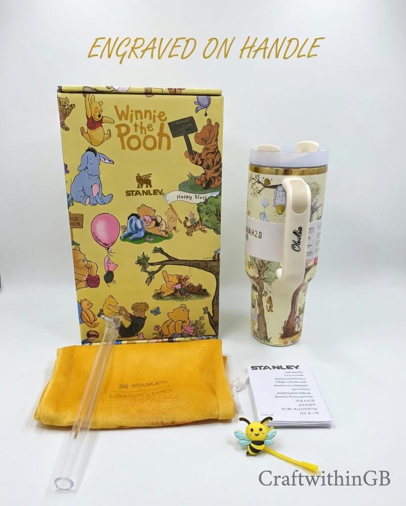 Puede incluir: Un vaso Stanley H2.0 con tem&aacute;tica de Winnie the Pooh con una caja de regalo, pajita y accesorios a juego. El vaso es de color crema con asa y tapa. La caja de regalo presenta ilustraciones de los personajes de Winnie the Pooh. Tambi&eacute;n se incluye un accesorio amarillo con forma de abeja.