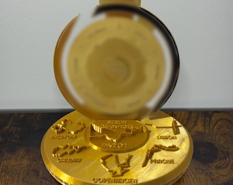 Puede incluir: Medalla dorada con diseño circular, con nombres de ciudades como Berlín y Cardiff. La medalla tiene una cinta y el texto "SUPERHALFS FINISHER". Probablemente un artículo conmemorativo para un evento de carrera.