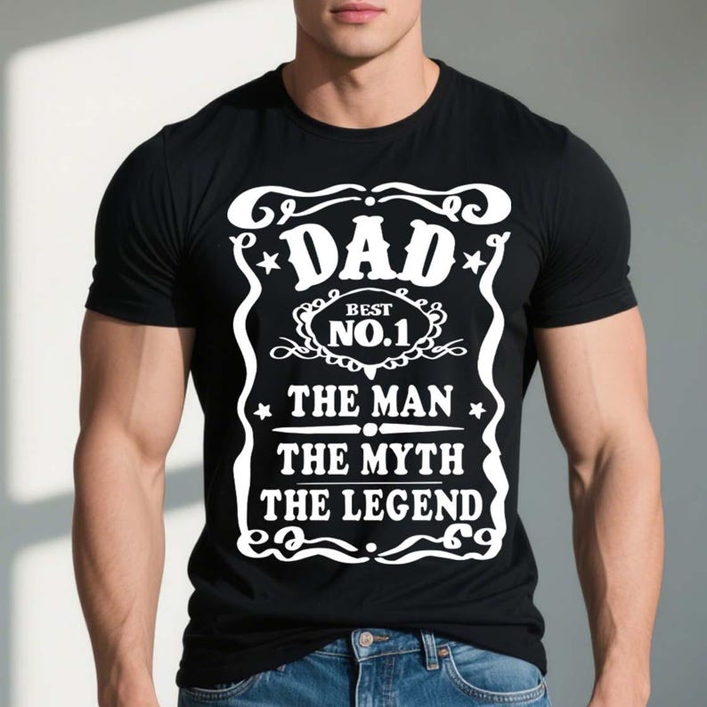 Pode incluir: Camiseta preta com um design gr&aacute;fico branco que diz "Dad - Best No. 1 - The Man The Myth The Legend".