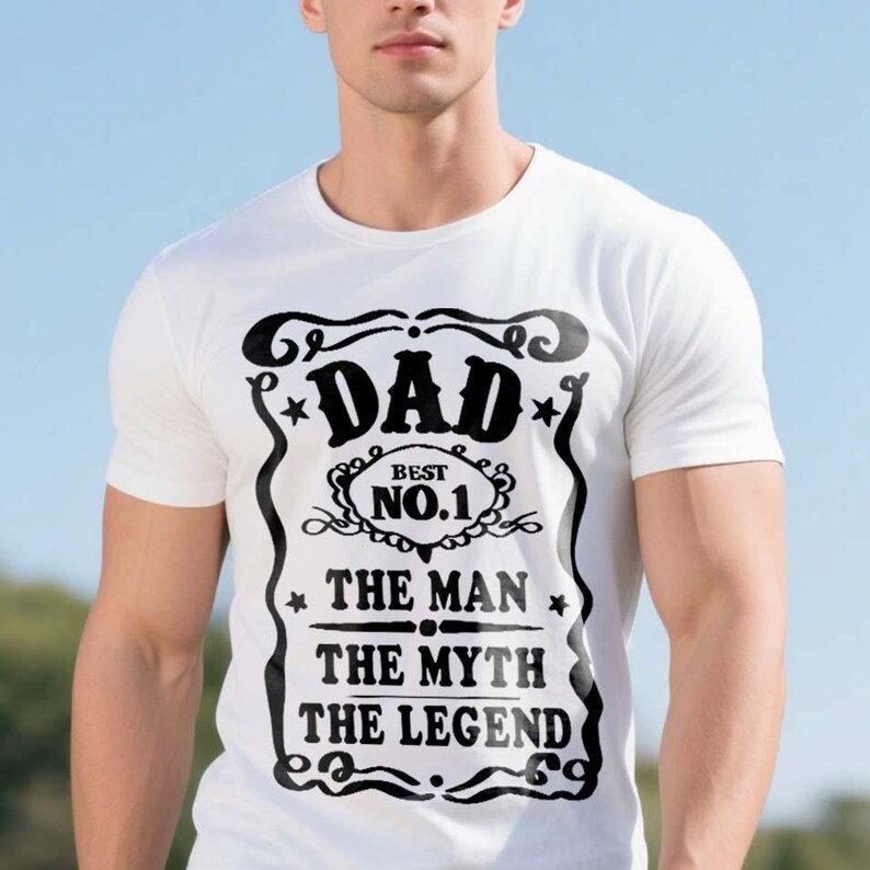Pode incluir: Camiseta branca com um design gr&aacute;fico preto que diz "Dad - Best No. 1 - The Man - The Myth - The Legend".