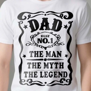 Pode incluir: Camiseta branca com um design gr&aacute;fico preto que diz "Dad Best No. 1 The Man The Myth The Legend".