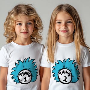 May include: Two children wearing white t-shirts with blue and black Thing 1 and Thing 2 graphics from the Dr. Seuss book, "The Cat in the Hat".