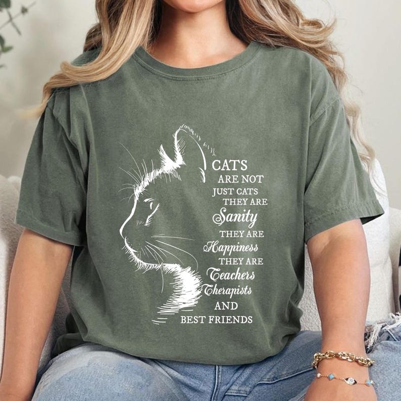 a woman sitting on a couch wearing a t - shirt with a picture of a