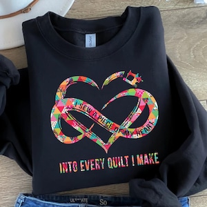 May include: Black sweatshirt with a colorful heart design and the text "I sew a piece of my heart into every quilt I make".