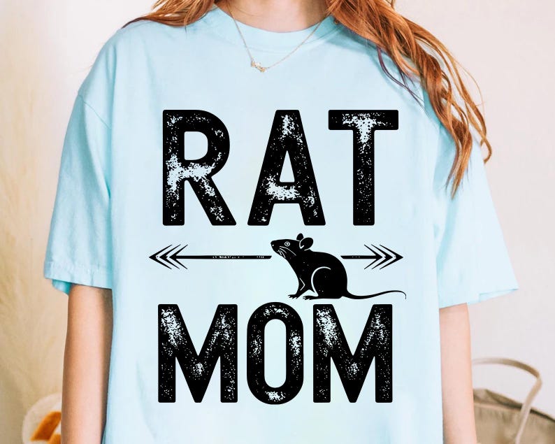 A person wearing a light blue t-shirt with the text "RAT MOM" printed on it.