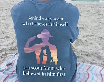 May include: A blue t-shirt with a silhouette of a scout saluting, with the text "Behind every scout who believes in himself is a scout Mom who believed in him first."