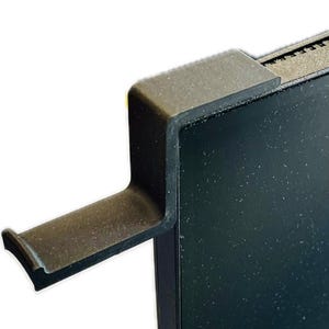 Könnte beinhalten: Schwarzer Monitorständer aus Kunststoff mit einem nach links gebogenen Arm. Der Ständer ist für die Aufnahme eines Monitors oder Laptops konzipiert.