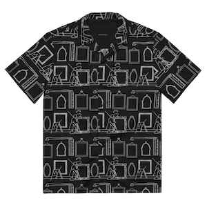 Puede incluir: Camisa negra de manga corta con botones y un estampado blanco de varios marcos, reglas y figuras colgando imágenes.