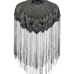 May include: A black cropped capelet featuring a high neckline and intricate silver beadwork in a decorative pattern. The garment is adorned with long, cascading silver beaded fringe that extends from the scalloped hemline to the bottom edge.