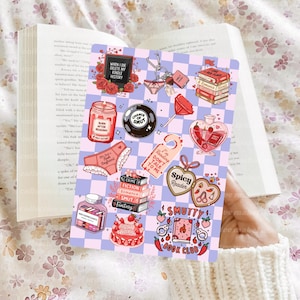 May include: A collection of stickers with a book theme, featuring phrases like "Burn After Reading" and "Spicy Reader." The stickers include images of books, lingerie, and a heart-shaped bottle, all set against a checkered background.