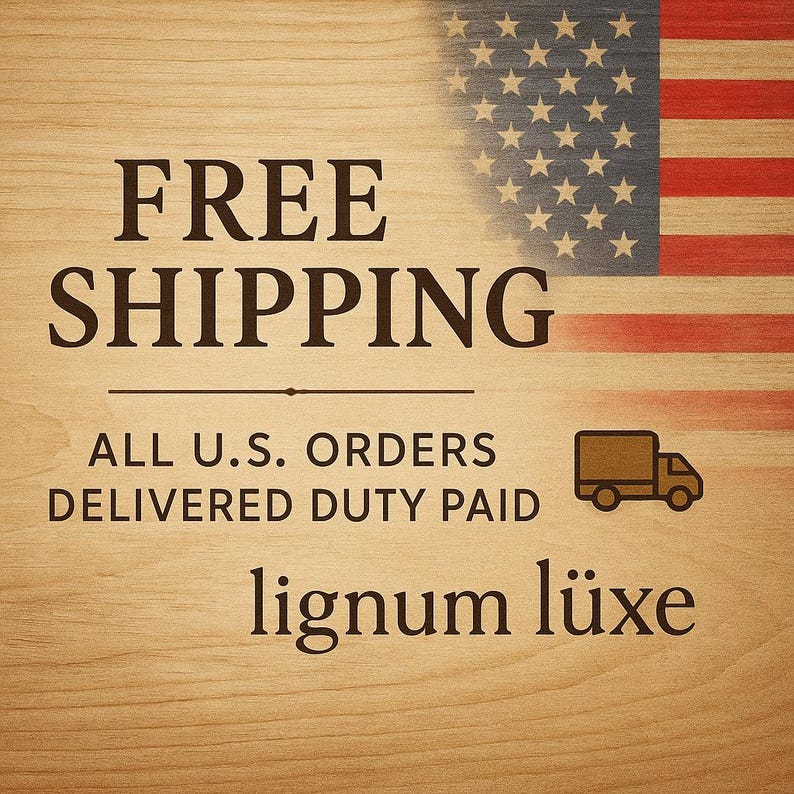 May include: A wooden background with the text "FREE SHIPPING" in a bold, dark brown font. The American flag is in the upper right corner. Below the text is "ALL U.S. ORDERS DELIVERED DUTY PAID" and the brand name "lignum l&uuml;xe".