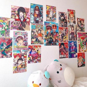 May include: A wall decorated with colorful anime manga magazine covers featuring characters from popular series like "My Hero Academia", "Fire Force", and "Jujutsu Kaisen".
