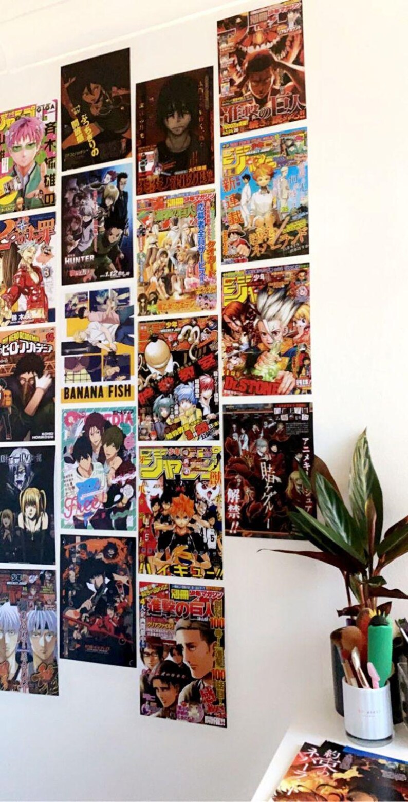 May include: A white wall with a collection of colorful anime magazine covers featuring characters from popular series like "Attack on Titan", "Hunter x Hunter", "Banana Fish", and "My Hero Academia".