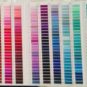 May include: A color chart displaying a wide array of thread colors. The chart is organized in vertical columns, showcasing shades of orange, red, pink, purple, blue, and green. Each color is represented by a series of thread samples.