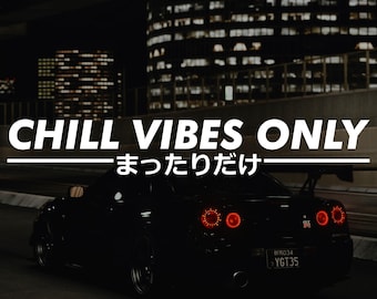 以下が含まれることがあります： 夜の道路を走る黒いスポーツカー。テールライトが赤く光っている。画像には「CHILL VIBES ONLY」の文字と日本語のテキストが書かれている。背景には街の明かりと建物が写っている。