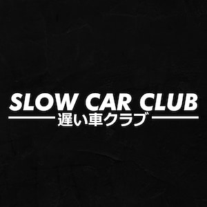 Può includere: Testo bianco su sfondo nero: "SLOW CAR CLUB" sopra caratteri giapponesi. Una linea bianca sottolinea il testo. Design semplice e audace, per gli appassionati di auto.