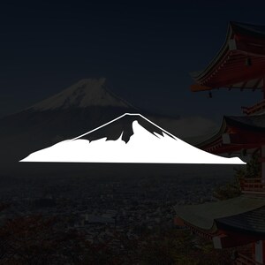 Könnte beinhalten: Eine weiße Grafik des Fuji-Berges vor dunklem Hintergrund. Der Berg befindet sich im Vordergrund, mit einem schneebedeckten Gipfel. Im Hintergrund eine verschwommene Ansicht einer Stadt und einer traditionellen japanischen Pagode mit roten und weißen Akzenten.