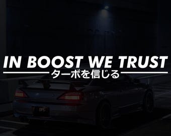 以下が含まれることがあります： 暗い画像。グレーのスポーツカー、スポイラー付き。薄暗い場所に駐車。上部に白い文字で「IN BOOST WE TRUST」、下に日本語。車のナンバープレートには「BPG」と記載。