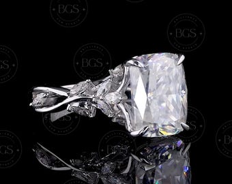 Könnte beinhalten: Ein silberfarbener Ring mit einem großen, rechteckigen Stein im Kissenschliff, der von vier Krappen gehalten wird. Die Ringschiene ist mit einer Reihe kleiner, marquise-geschliffener Steine in blattartigem Muster verziert.