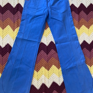 May include: A pair of blue bell bottom pants with a tag that says "Lenny Bruce" on it.