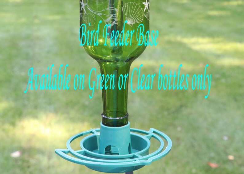 Op de afbeelding: Een vogelvoederbak-basis van een groene glazen fles met witte ge&euml;tste schelp- en zeesterontwerpen. De tekst Bird Feeder Base en Available on Green or Clear bottles only is in het lichtblauw over de fles en de voederbak gedrukt.