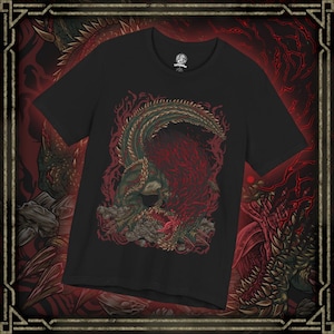 Peut inclure: T-shirt noir avec une illustration détaillée d'un dragon aux écailles vertes et rouges. Le dragon est représenté avec une longue queue et une expression menaçante. Le design est sur fond rouge.