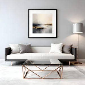 Puede incluir: Sal&oacute;n moderno con un sof&aacute; blanco con cojines grises y blancos, una mesa de centro con tapa de cristal y base geom&eacute;trica cobriza, y una pintura abstracta enmarcada. Una l&aacute;mpara de pie con pantalla blanca tambi&eacute;n est&aacute; presente.