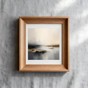Puede incluir: Impresi&oacute;n art&iacute;stica de paisaje abstracto en un marco de madera natural. La obra presenta una escena serena con tonos apagados de gris, dorado y beige, evocando una sensaci&oacute;n de calma. El marco es de color marr&oacute;n claro.