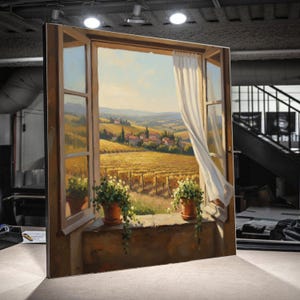 May include: A framed painting depicts a Tuscan landscape viewed through an open window. The artwork showcases a golden field, vineyards, and distant buildings under a blue sky. Two potted plants sit on the windowsill, and a white curtain billows in the breeze.