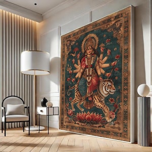 May include: Large framed artwork depicting a multi-armed deity riding a tiger. The artwork features a teal background with floral and ornate border details. The deity is adorned in red and blue garments, with a golden halo. A lotus flower is at the bottom.