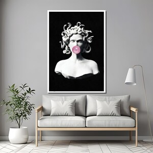 Puede incluir: Una imagen en blanco y negro de un busto de Medusa con serpientes como cabello, soplando una burbuja rosa. El busto est&aacute; sobre un fondo negro.