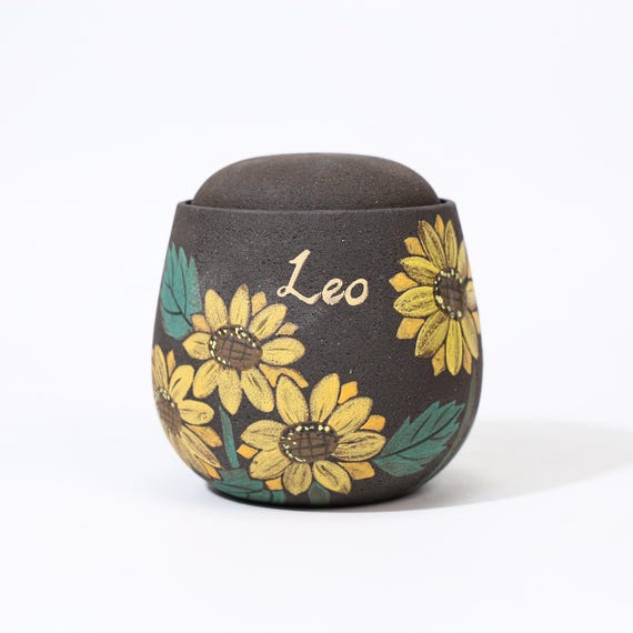 A hand-painted ceramic pet urn with custom sunflower art — deeply personal, visually beautiful, and irreplaceable for grieving pet owners.